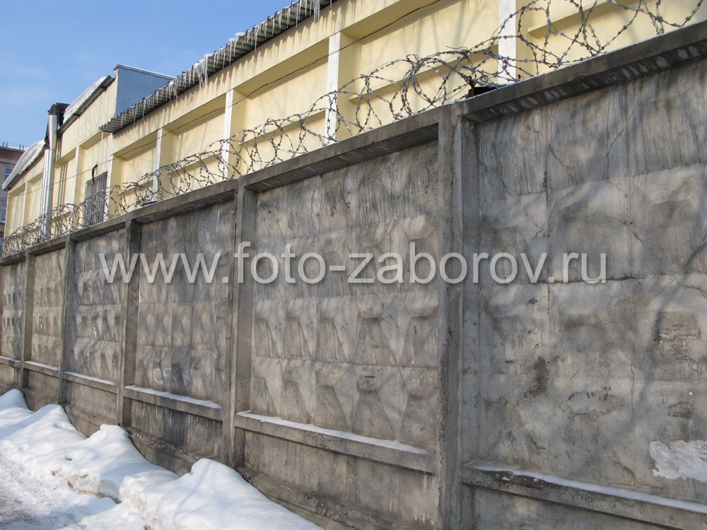 Фото Старый железобетонный заводской забор продолжает выполнять свою защитную функцию даже при