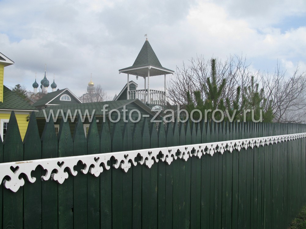 Фото Деревянный забор с резным декором как часть единого архитектурного ансамбля гостиницы