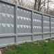 Классический бетонный забор промышленного предприятия. Панели установлены в бетонные стаканы.