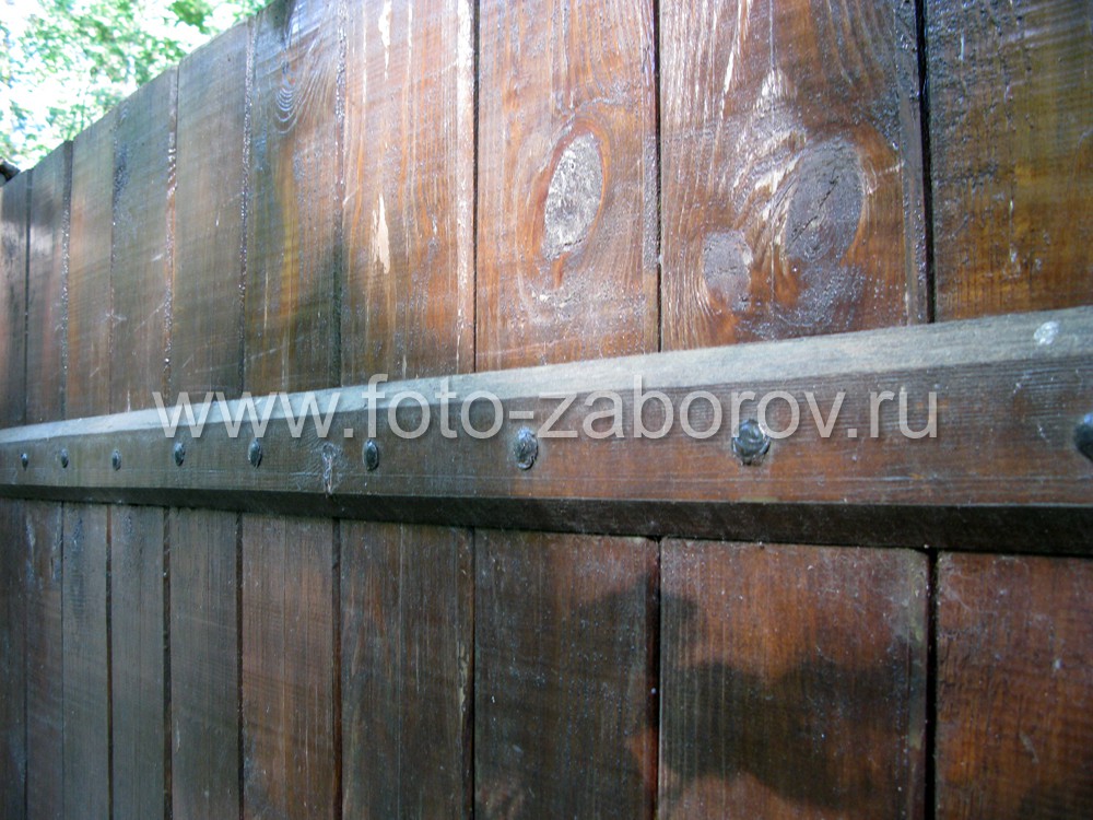 Фото Деревянный забор тёмно-коричневого цвета с облицованными столбами 