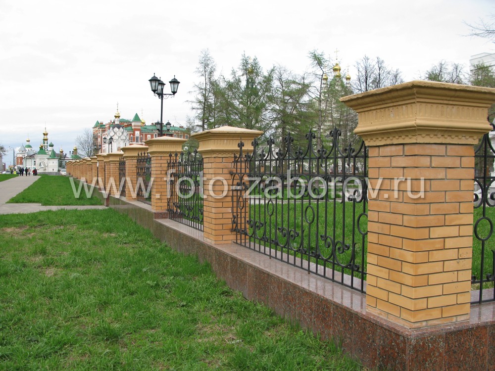 Фото Кованая ограда с массивными кирпичными столбами в окантовке из гранитных плит для городского