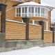 Элитный кирпичный забор на высоким бетонном фундаменте. Надёжная защита нового дома из жёлтого кирпича.