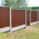 Забор комбинированный с евростолбами и цокольной плитой. Заполнение пролётов и откатных ворот коричневым профнастилом RAL 8017. 