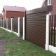 Секционные ворота-рольставни и евроштакетник на бетонных столбах - современные технологии в заборостроении.
