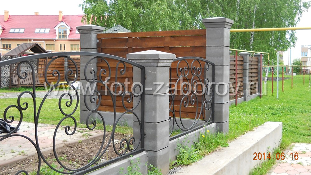 Фото Красивый кованый забор на бетонных столбах в сочетании с габионами и деревянной