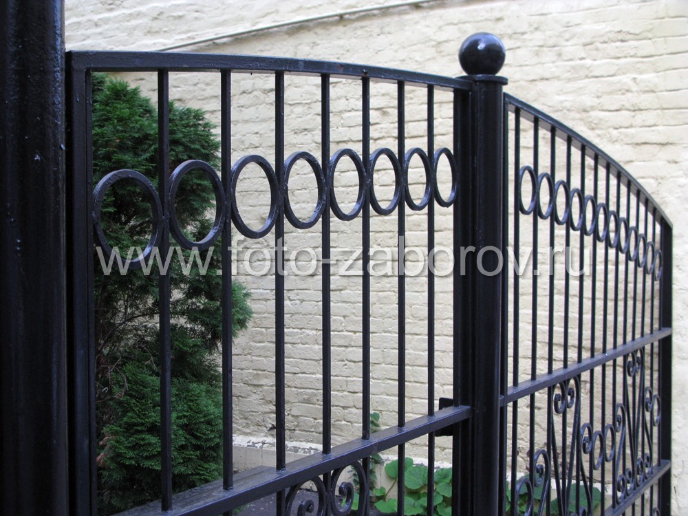 Фото Простой изящный металлический забор с кованым декором. Средняя секция - в виде широкой