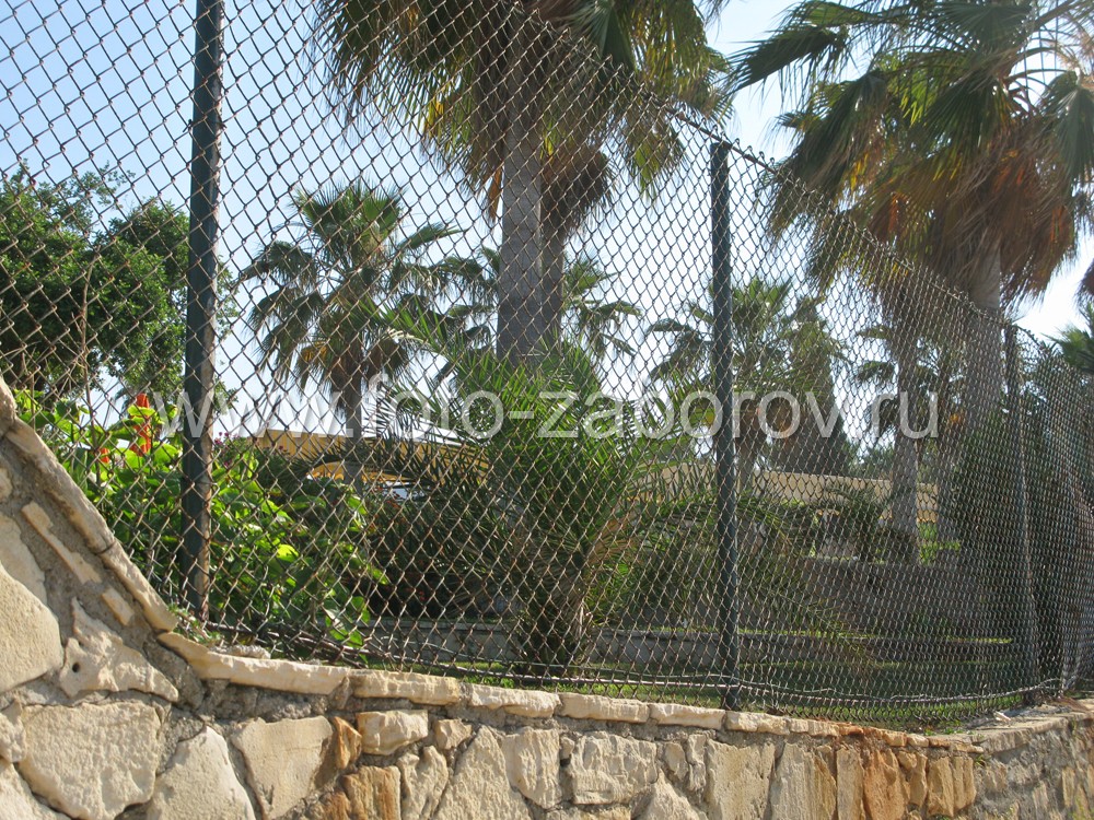 Фото Использование природного камня и высокой сетки-рабицы для ограды