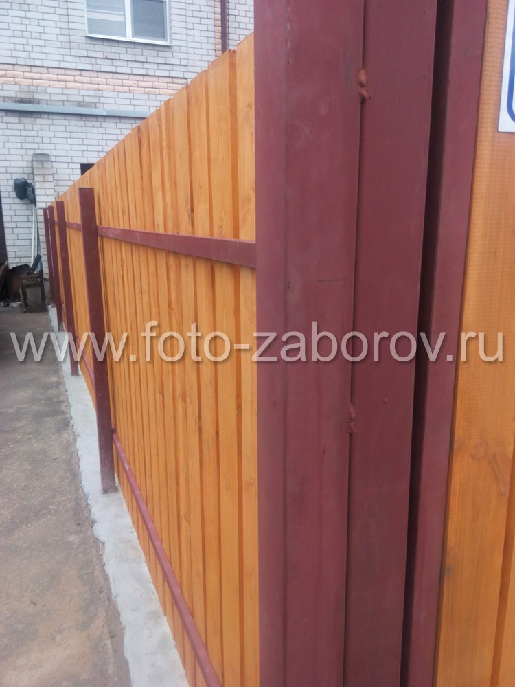 Фото Забор из деревянного штакетника. Монтаж штакетин - с зазором, в основании забора - бетонный