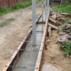Заливка ленточного бетонного фундамента для элитного забора с кирпичными столбами и заполнением профлистом.