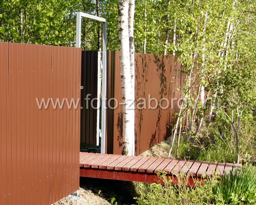 Фото Забор из коричневого профнастила и мостик, перекинутый через