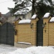 Кирпичный забор коттеджа и фигурные металлические ворота в полной комплектации.